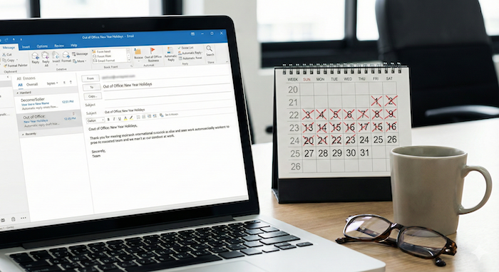 Office desk, out-of-office email. (オフィスの机、不在メール。)